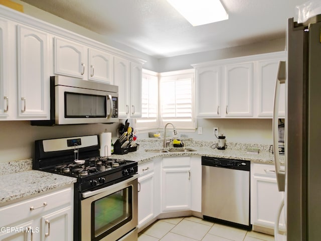 kitchen featuring light stone counters, appliances with stainless steel finishes, sink, and white cabinets