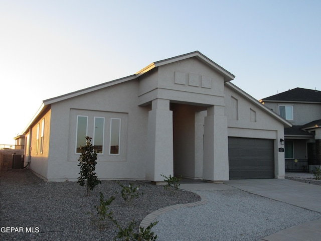 view of front facade featuring a garage and central air condition unit