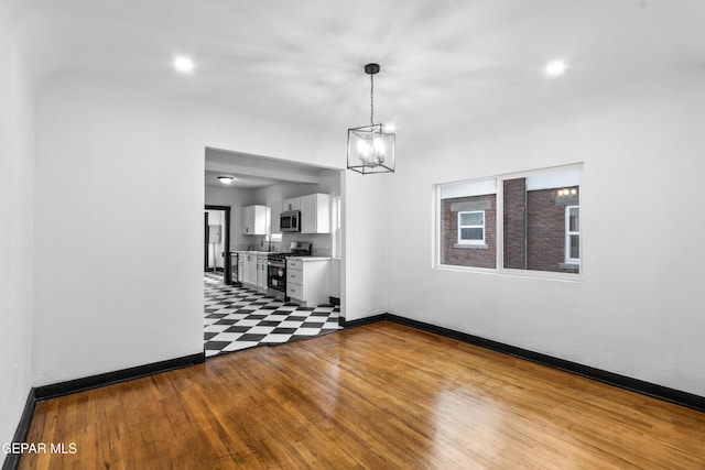 unfurnished dining area with sink, a chandelier, and light wood-type flooring