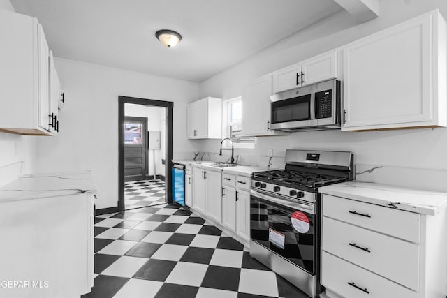 kitchen featuring stainless steel appliances, sink, and white cabinets