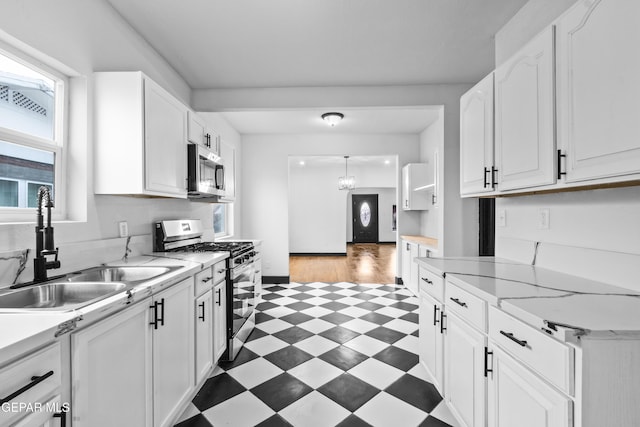 kitchen featuring a healthy amount of sunlight, sink, white cabinets, and appliances with stainless steel finishes