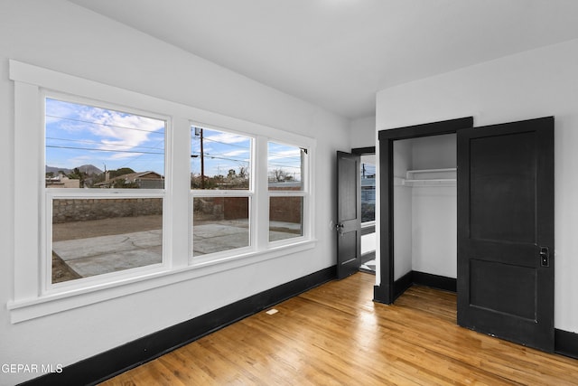 unfurnished bedroom with a closet and light wood-type flooring