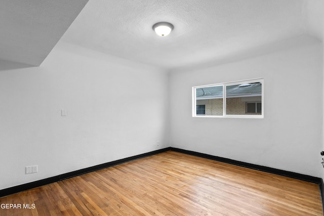 empty room featuring hardwood / wood-style flooring and a textured ceiling