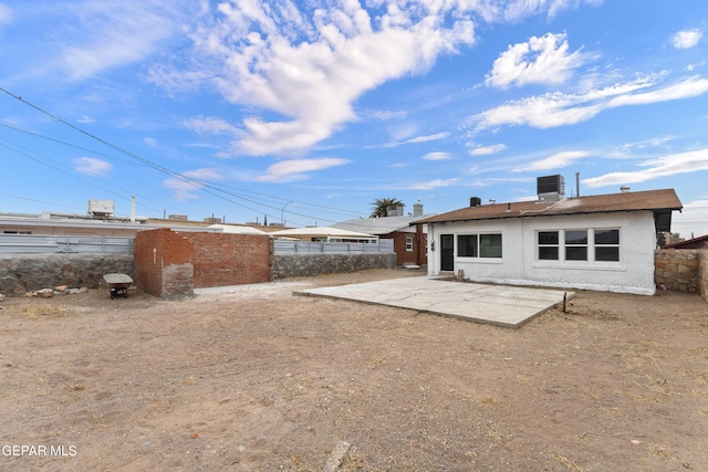 rear view of property with central AC unit and a patio area