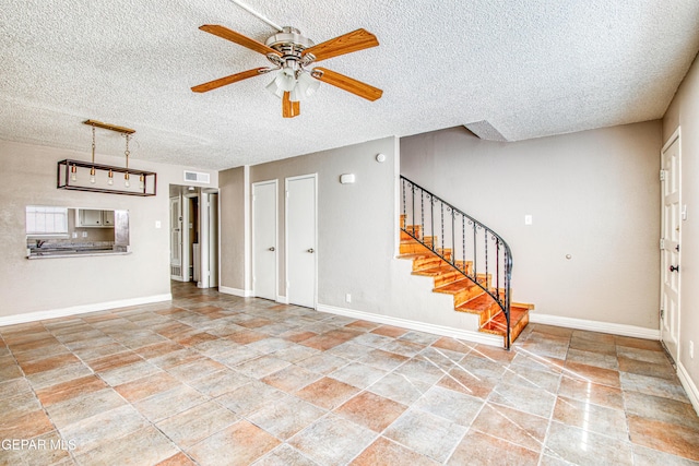 unfurnished living room featuring a textured ceiling and ceiling fan