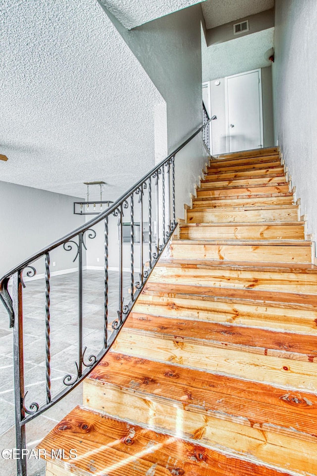 stairs with a textured ceiling