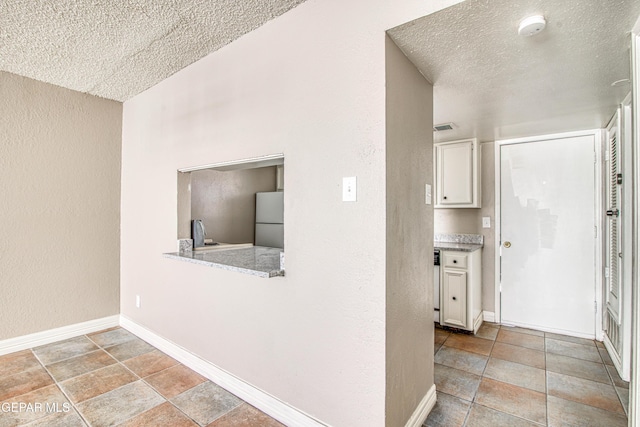 hallway featuring sink and a textured ceiling