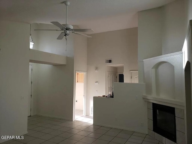 unfurnished living room featuring light tile patterned floors, baseboards, visible vents, a ceiling fan, and high vaulted ceiling