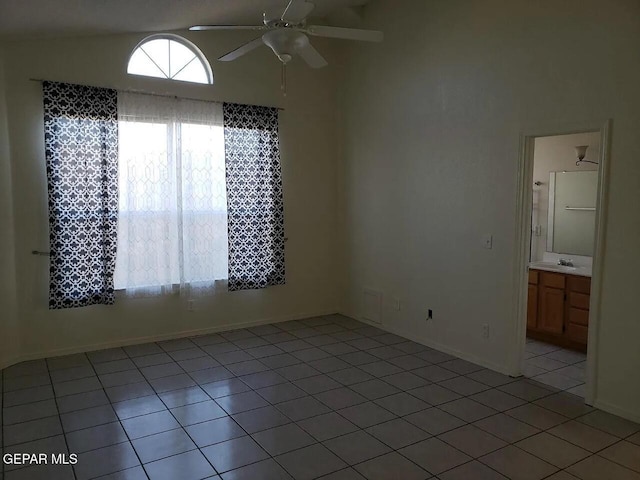 empty room with ceiling fan, a sink, light tile patterned flooring, and lofted ceiling