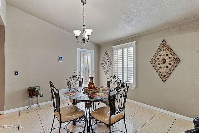 tiled dining space featuring lofted ceiling, a textured ceiling, and a chandelier