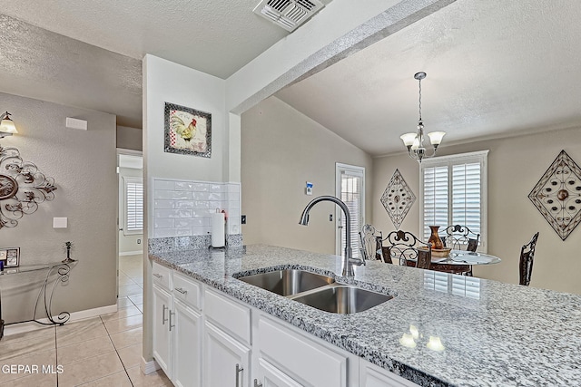 kitchen featuring sink, light stone countertops, and white cabinets