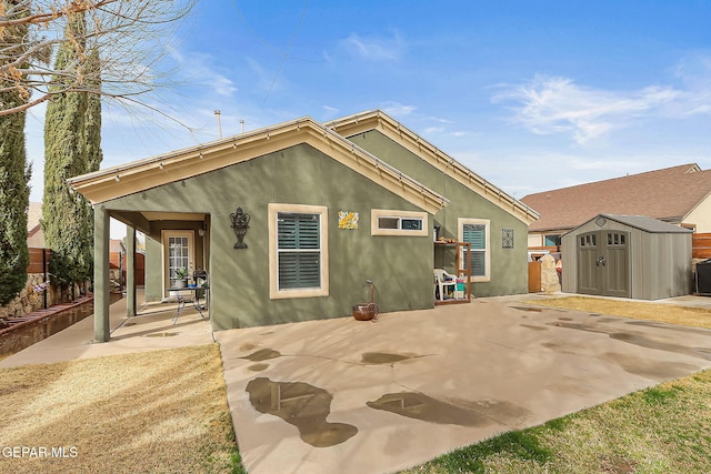 back of house featuring a shed and a patio area