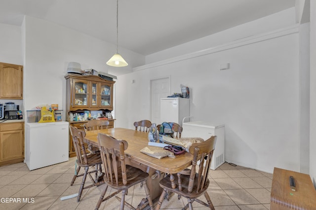 dining area with light tile patterned flooring, washer / clothes dryer, and lofted ceiling