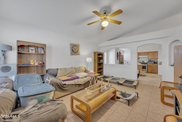 tiled living room with ceiling fan and lofted ceiling