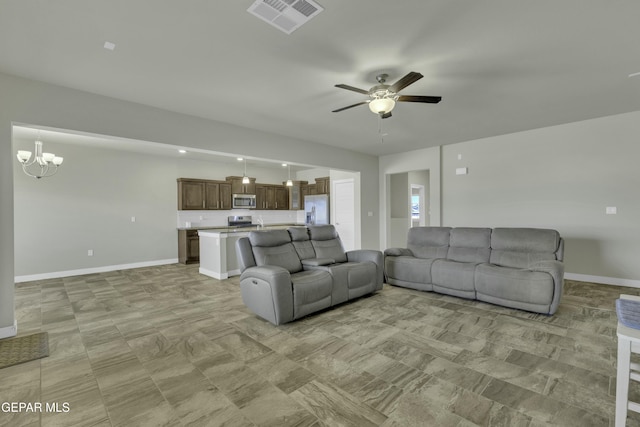 living room featuring ceiling fan with notable chandelier