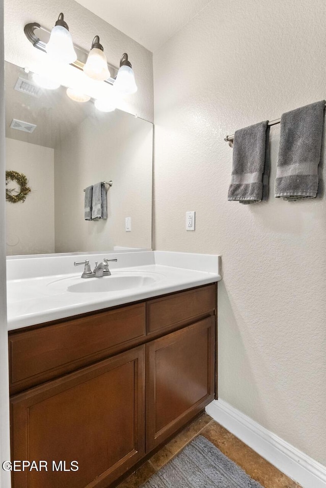 bathroom with baseboards, visible vents, and vanity