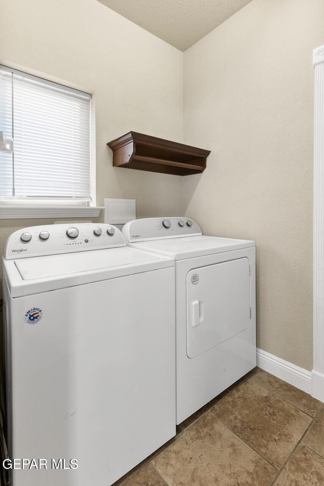 laundry area featuring laundry area, baseboards, and washer and dryer