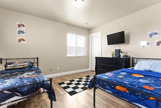 bedroom featuring baseboards and wood finished floors