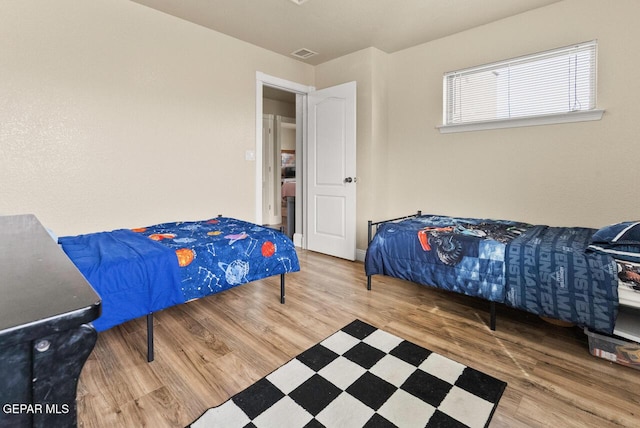 bedroom with wood finished floors and visible vents