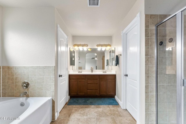 full bathroom with a sink, visible vents, a shower stall, a bath, and double vanity