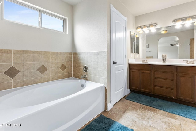 full bathroom featuring tile patterned floors, double vanity, a sink, and a bath