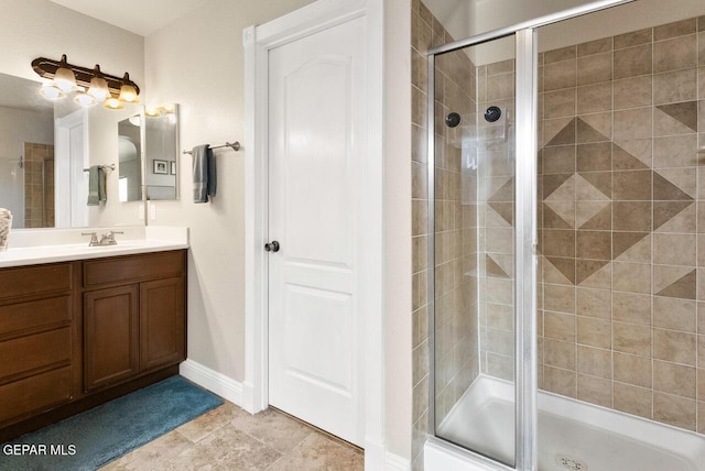 full bath featuring a shower stall, vanity, and baseboards