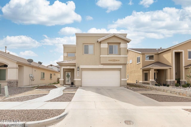 view of front of home with an attached garage, a tiled roof, concrete driveway, and stucco siding