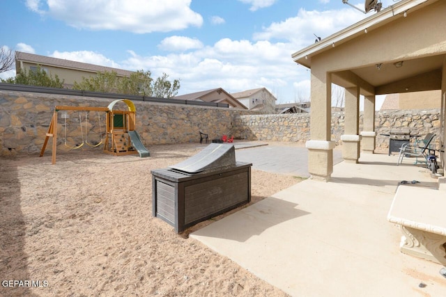 view of patio with a playground and a fenced backyard