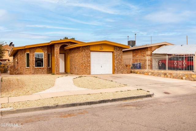 single story home featuring a garage and central AC unit