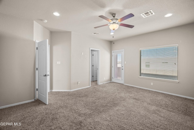 unfurnished room with carpet, ceiling fan, and a textured ceiling