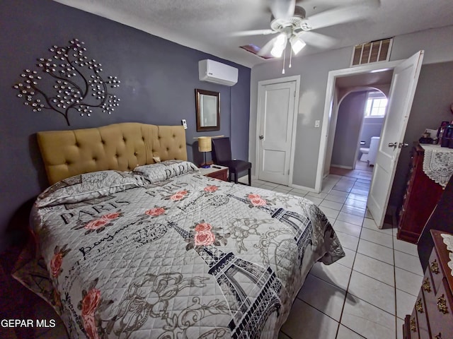 tiled bedroom featuring a ceiling fan, baseboards, visible vents, and an AC wall unit