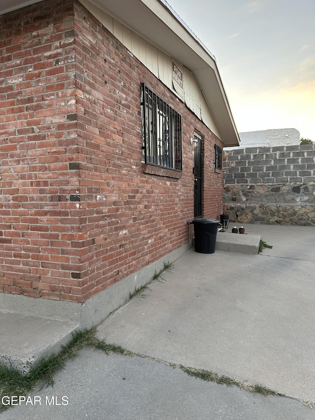 view of side of property featuring a patio area and brick siding