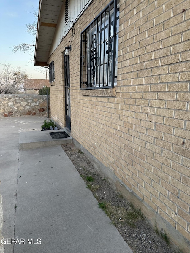 view of side of home with a patio area and brick siding