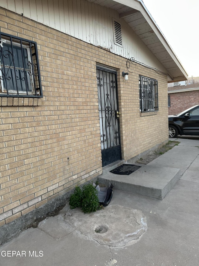 entrance to property featuring brick siding