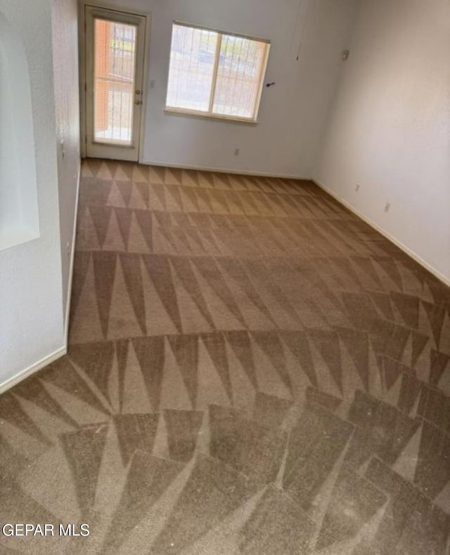 unfurnished room with dark carpet