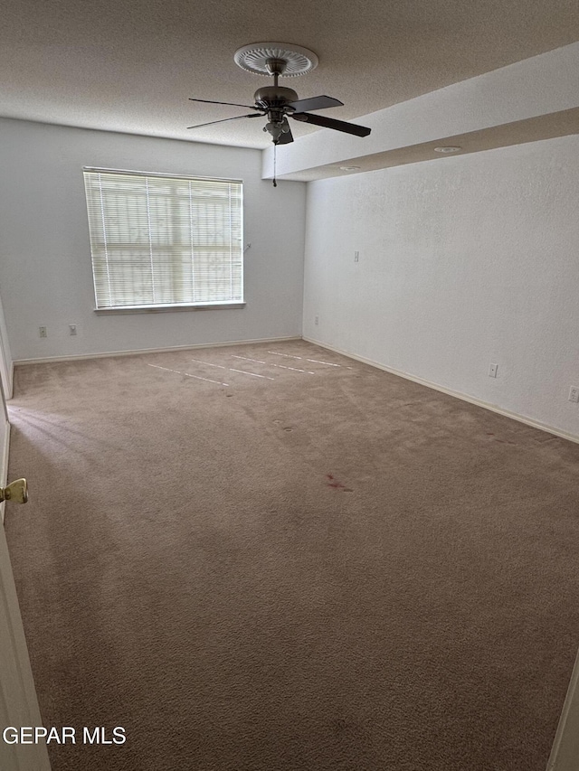 carpeted empty room featuring a textured ceiling and ceiling fan