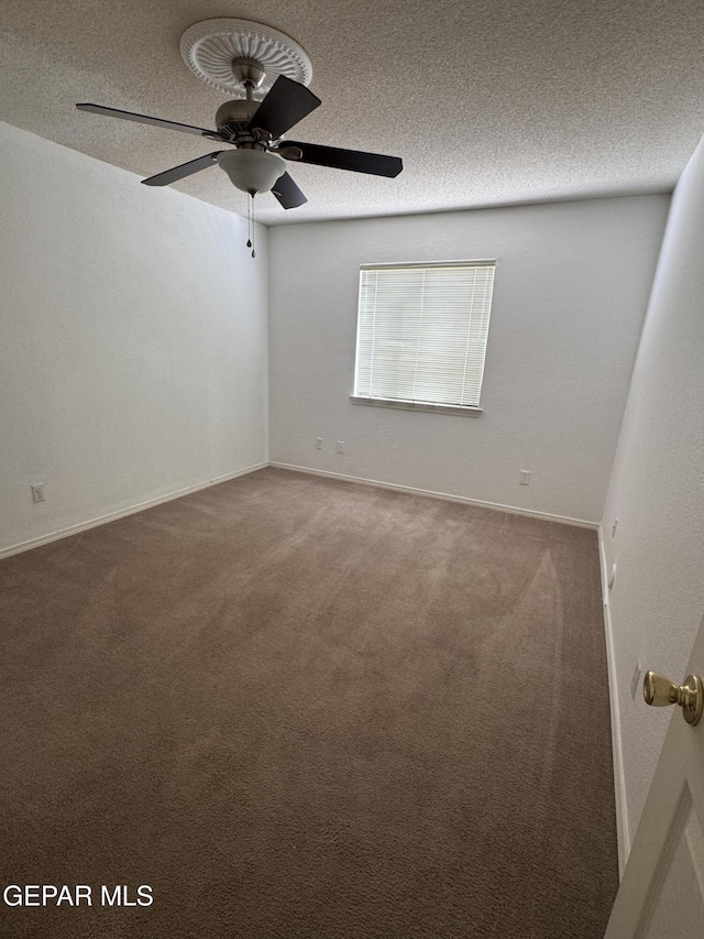 spare room with a textured ceiling, carpet flooring, and ceiling fan