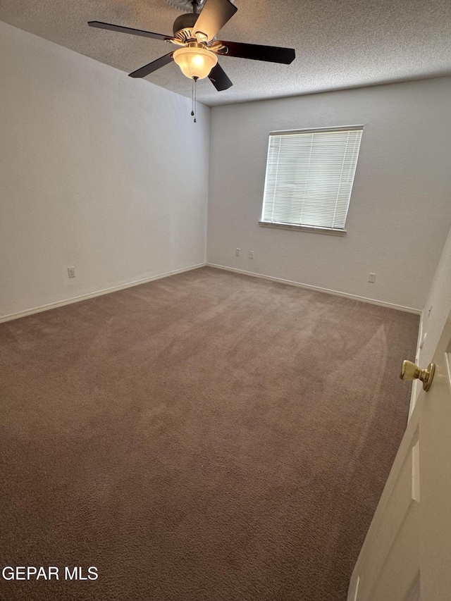 carpeted spare room featuring a textured ceiling and ceiling fan