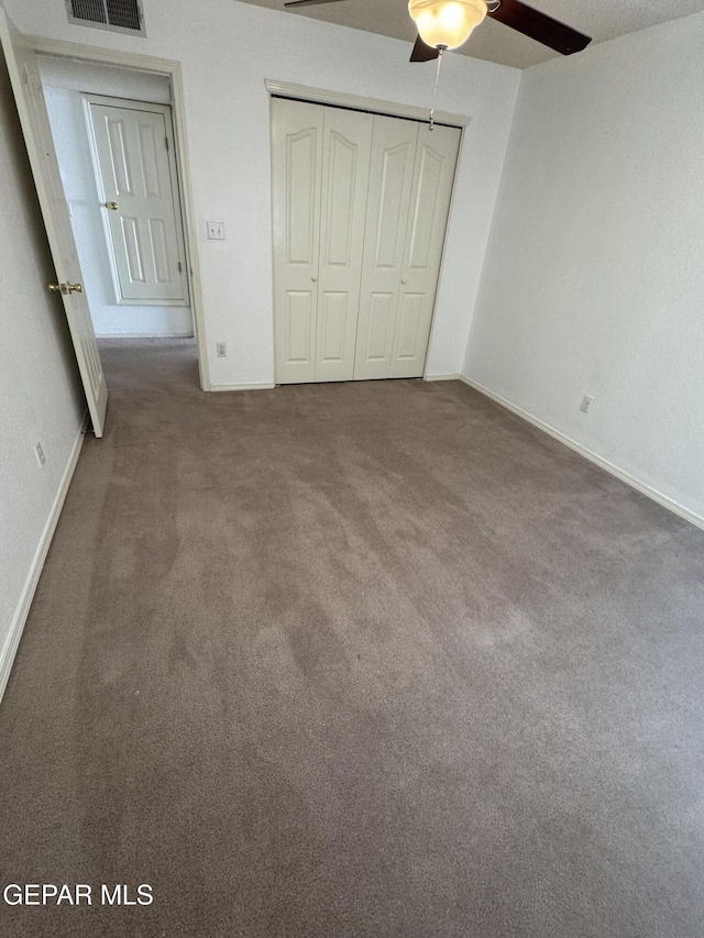 unfurnished bedroom with carpet floors, a closet, and ceiling fan