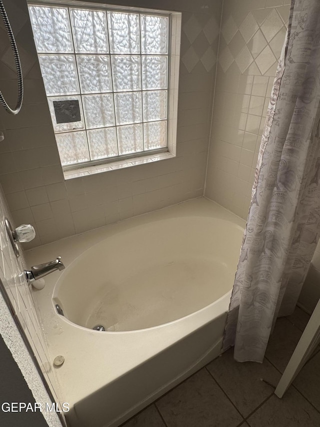 bathroom with tile patterned floors and shower / bath combo with shower curtain