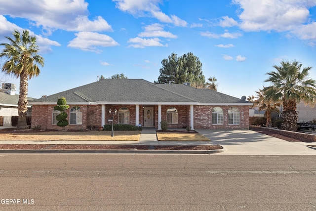 view of front of property featuring a shingled roof and brick siding