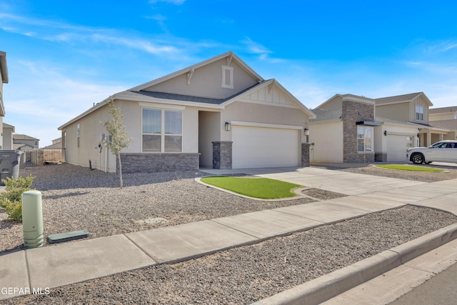 view of front of home featuring driveway, stone siding, an attached garage, and stucco siding