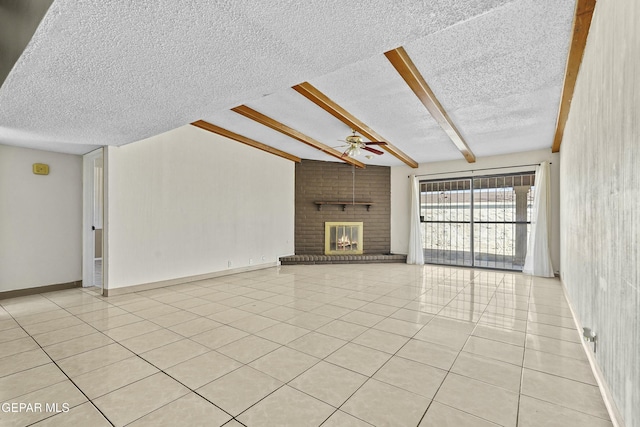 unfurnished living room with a brick fireplace, light tile patterned floors, beamed ceiling, and a textured ceiling