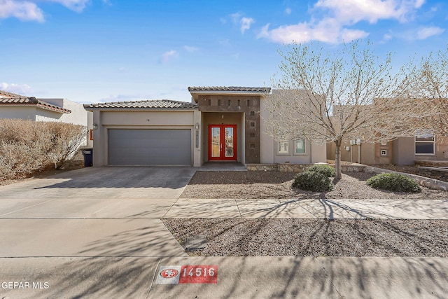 mediterranean / spanish-style home featuring a garage, decorative driveway, a tile roof, and stucco siding