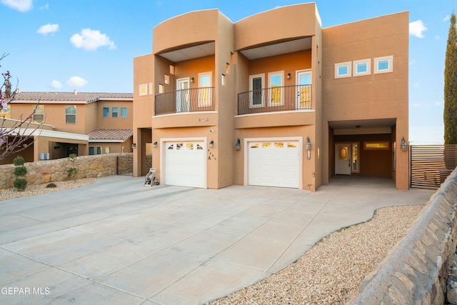 adobe home featuring driveway, a garage, and stucco siding