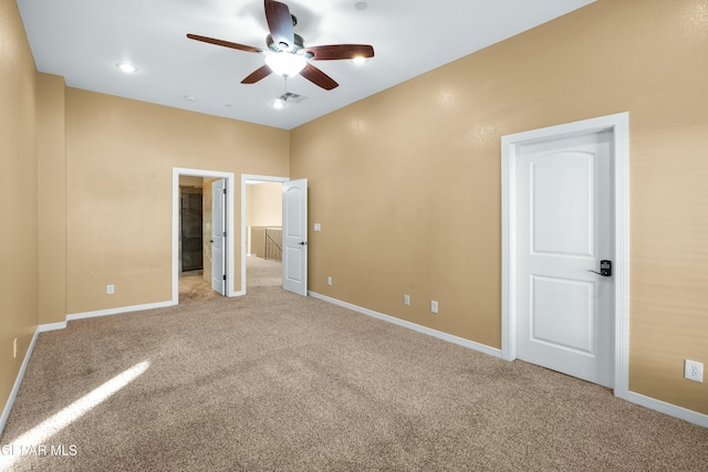 unfurnished bedroom with carpet floors, a spacious closet, visible vents, and baseboards