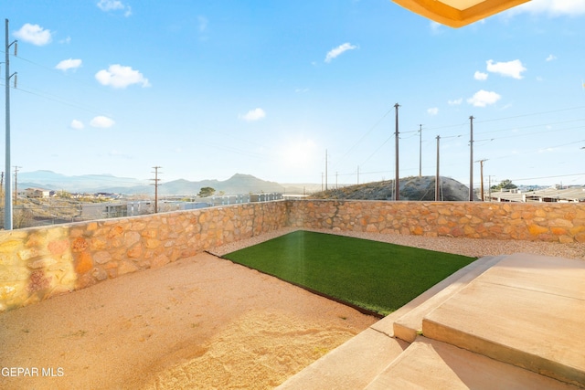 view of yard featuring a patio area, a fenced backyard, and a mountain view