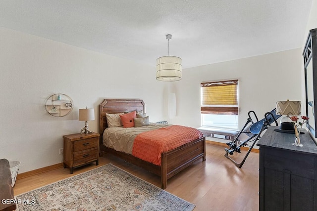 bedroom with hardwood / wood-style floors and a textured ceiling