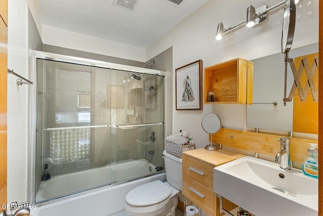 full bathroom with sink, toilet, and enclosed tub / shower combo