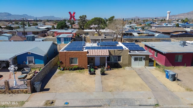 exterior space featuring a residential view, roof mounted solar panels, a tile roof, and a mountain view